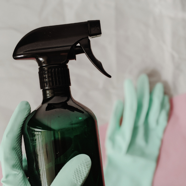 green spray bottle with green gloves