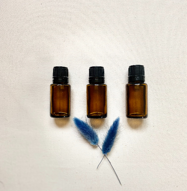 essential oils in a row with blue leaves