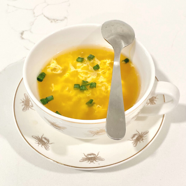 soup with green onions in a white bowl with a spoon