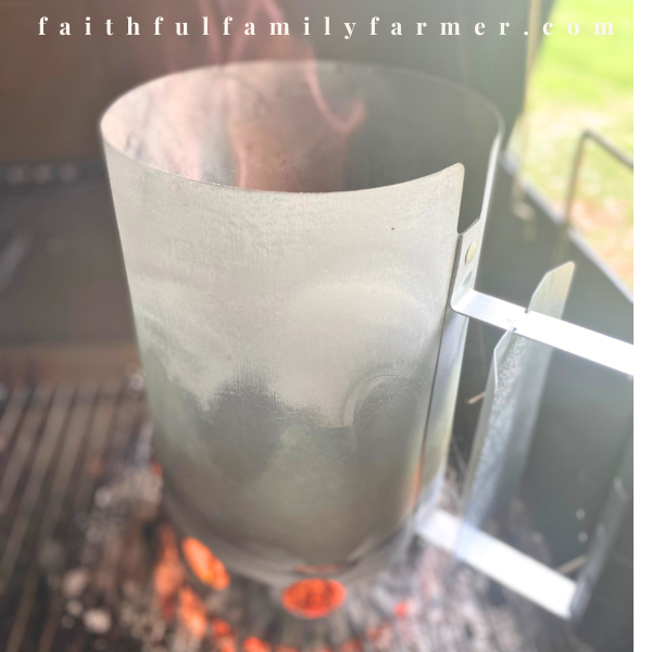 lit charcoal chimney in bbq pit