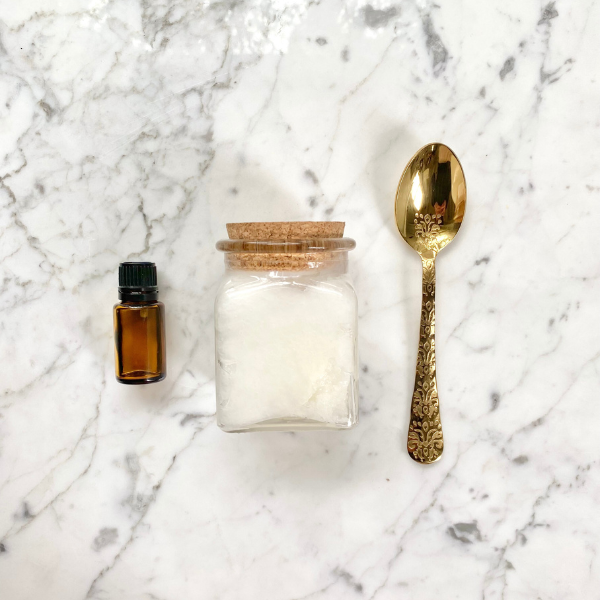 coconut oil with gold spoon and essential oil 