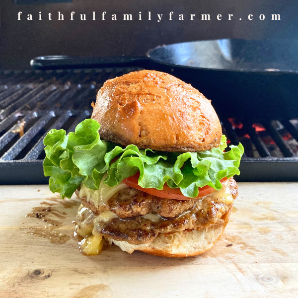 Rabbit smash burgers on cutting board in front of bbq grill