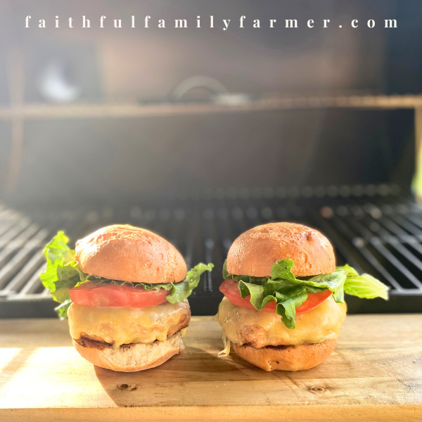 smoked and grilled rabbit burgers on cutting board next to bbq pit